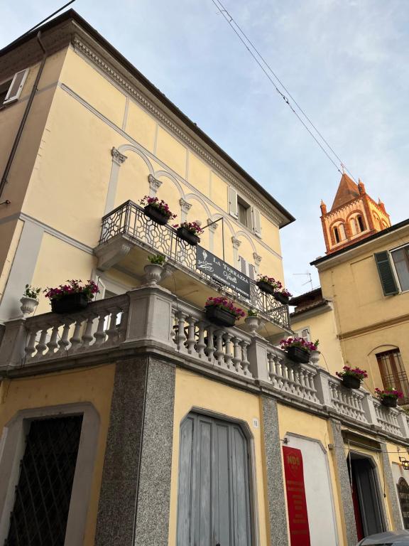 ein Gebäude mit einem Balkon mit Blumen darauf in der Unterkunft La Terrazza Vercelli Bed & Charme in Vercelli