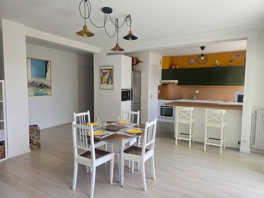 une cuisine et une salle à manger avec une table et des chaises dans l'établissement Le Loft Blainville, à Dieppe