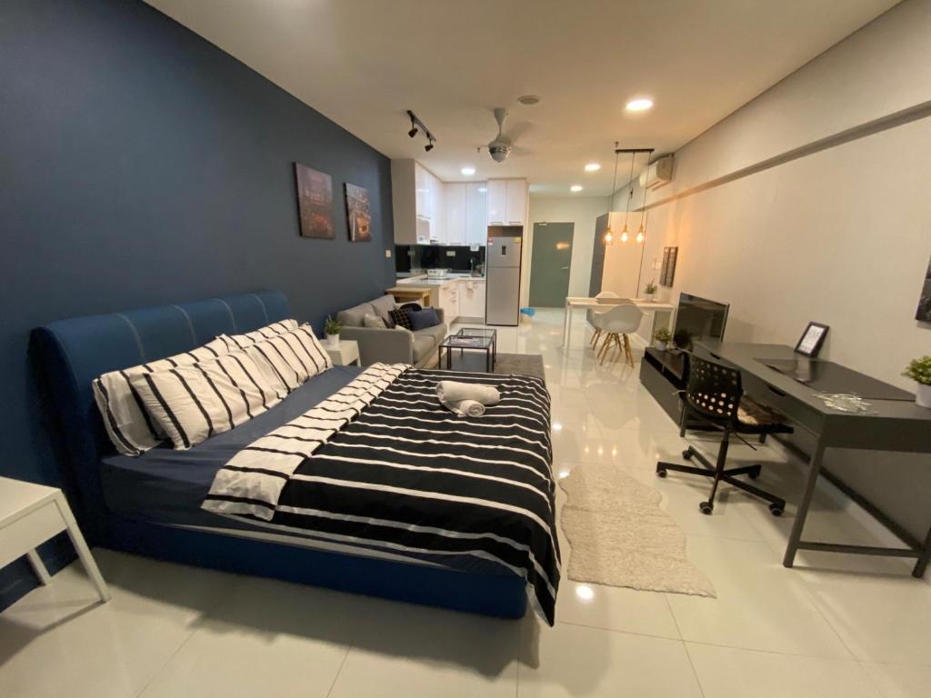 sypialnia z niebieskim łóżkiem i biurkiem w obiekcie Summer Suites KLCC By Whollmark w Kuala Lumpur