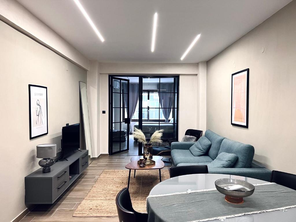 a living room with a blue couch and a table at Modiano Luxury Apartment Thessaloniki in Thessaloniki