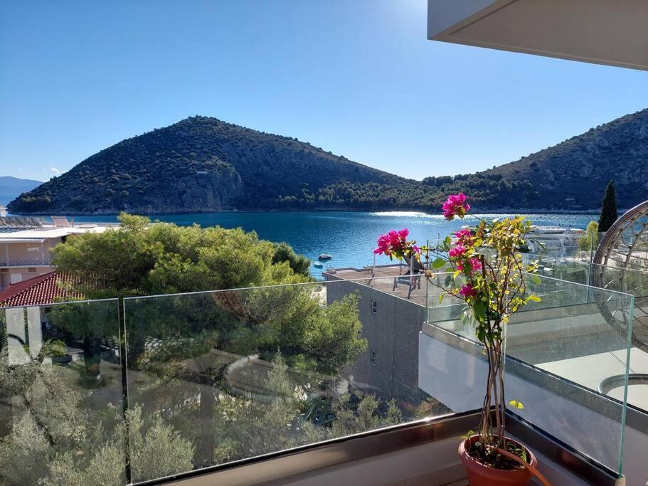 a view of a lake from a balcony with flowers at Gesyl Apartment in Tolo