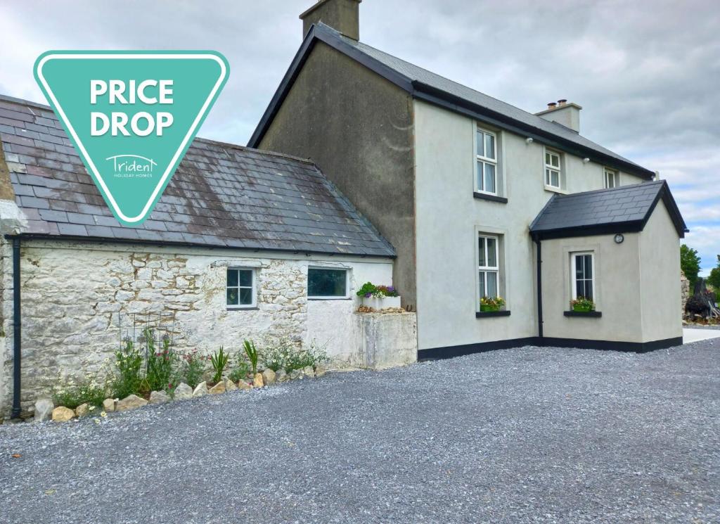 una casa con un cartello di sconto prezzo davanti di Rowan House Holiday Home 