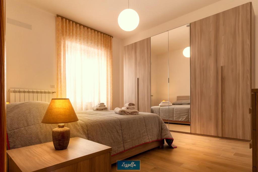 ein Schlafzimmer mit einem Bett und einer Lampe auf einem Tisch in der Unterkunft Zezzella Tourist Lease in Locorotondo