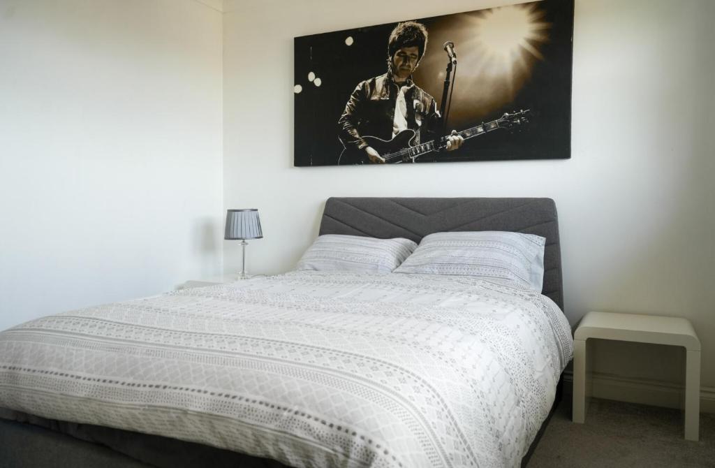 a bedroom with a bed with a picture of a guitarist at Modern Apartment Ayr Town Centre in Prestwick