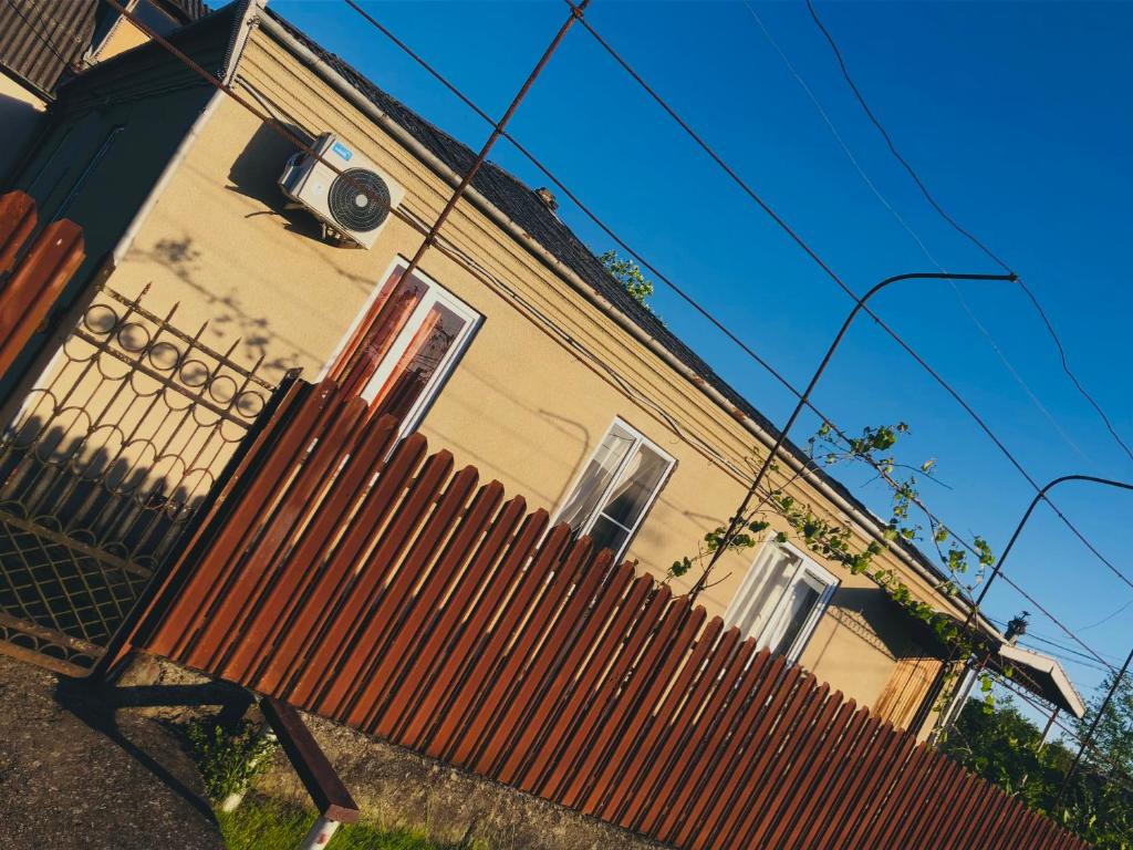 un banco de madera frente a un edificio en Чёрное Море, en Ochamchira