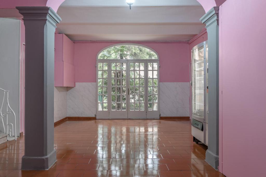 an empty room with pink walls and an arched door at Saragozza Apartments in Bologna