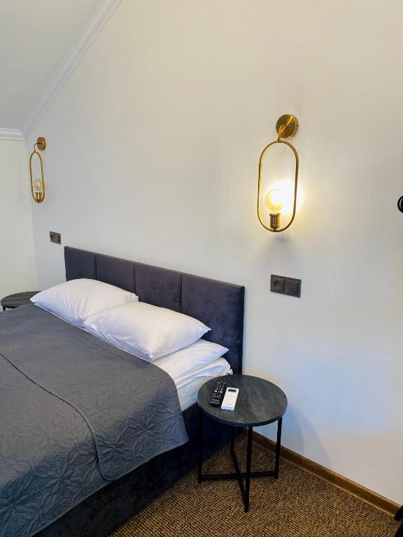 a bedroom with a bed and a table with a lamp at Райский Дворик in Pogreby