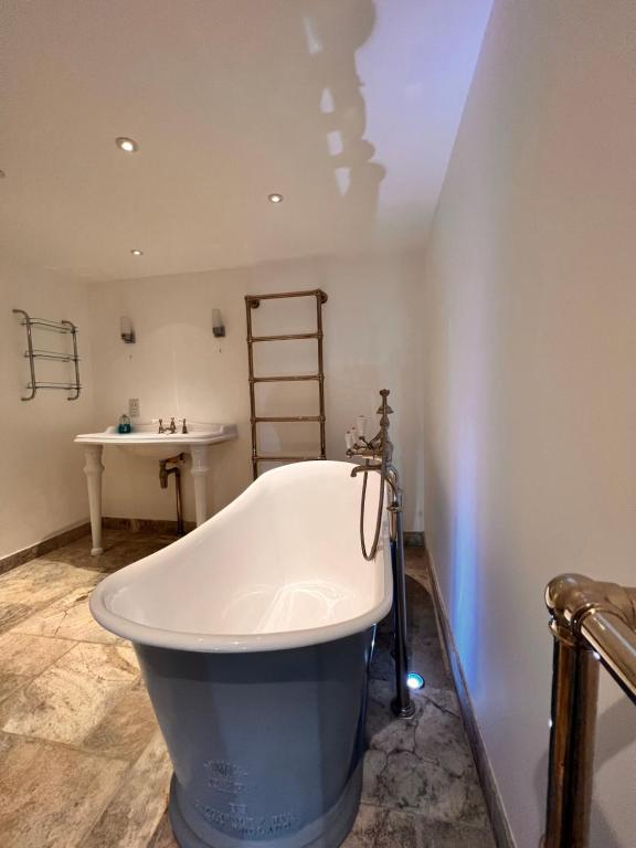een groot bad in een badkamer met een wastafel bij Knightsbridge villa, Westminster in Londen