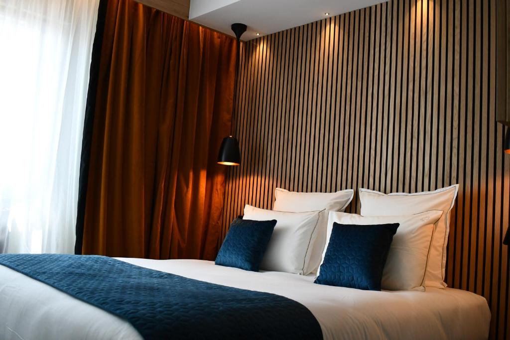 מיטה או מיטות בחדר ב-Le Cheval Blanc - Lac du Der - Logis Hotel