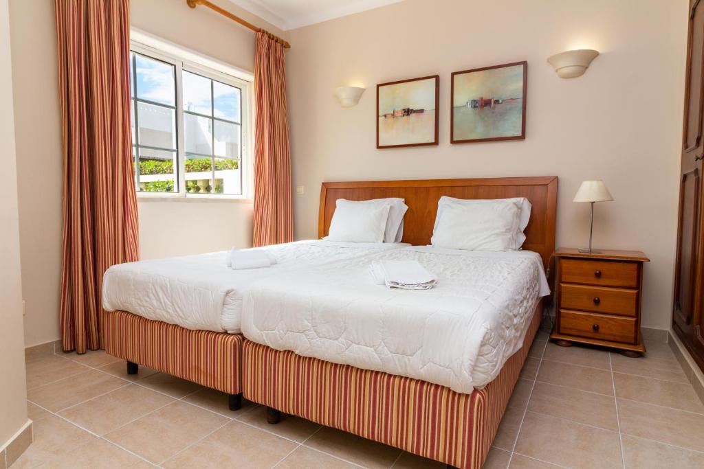 a bedroom with a large bed and a window at Vila do Castelo in Albufeira