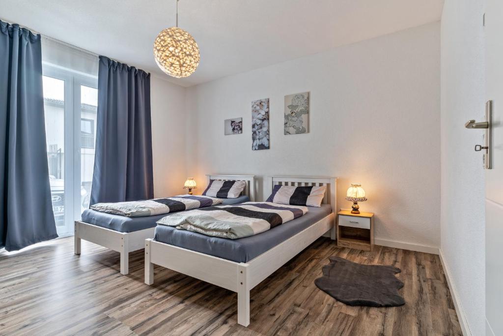 - 2 lits dans une chambre avec des rideaux bleus dans l'établissement Familie Richter, à Lahr/Schwarzwald