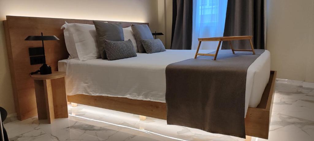 Un dormitorio con una cama grande con una silla. en Potnia Athens, en Atenas