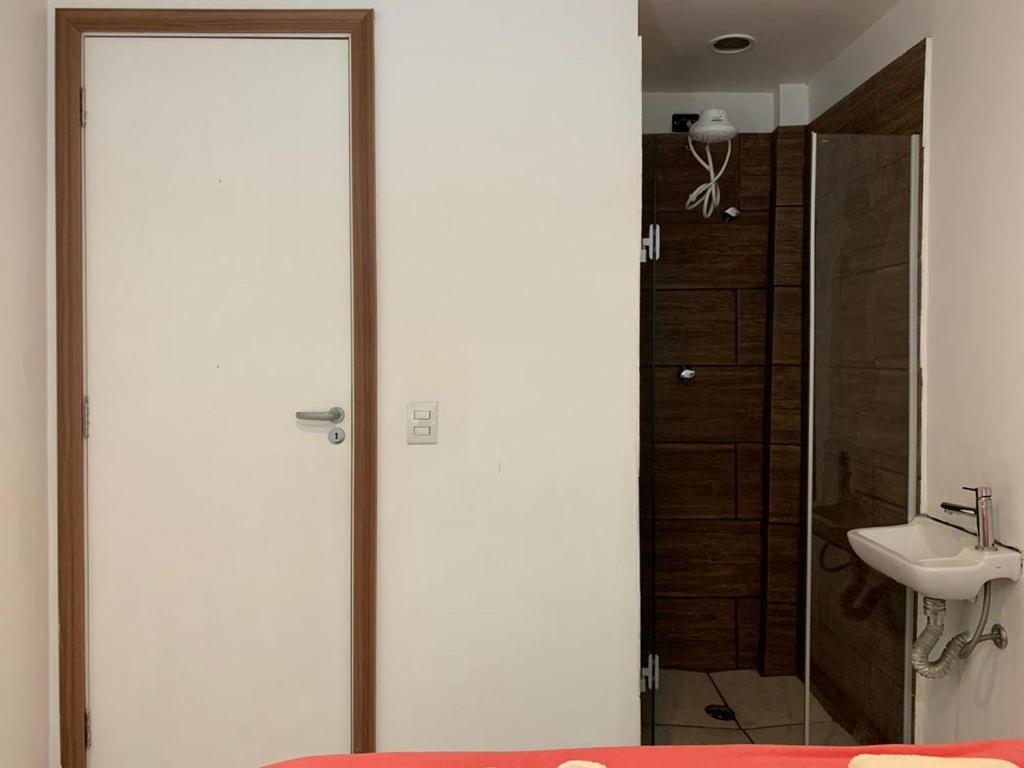 La salle de bains est pourvue d'une douche et d'un lavabo. dans l'établissement Kambô hostel, à São Paulo