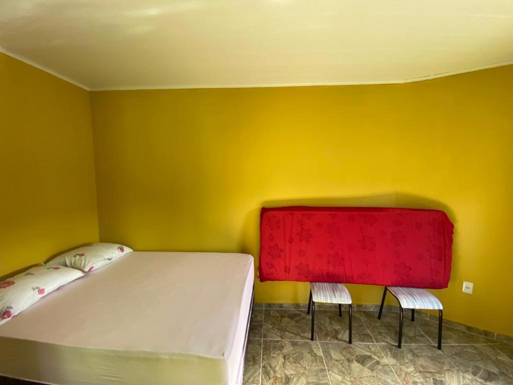 Chalé Lagoa do Pau في كوروريبي: غرفة نوم بسرير ابيض وكرسيين