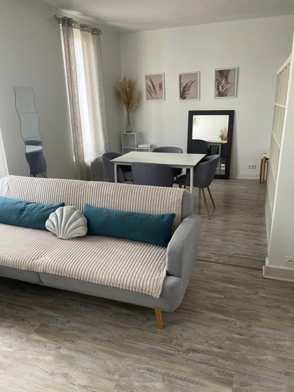 un salon avec un canapé et une table dans l'établissement Le Voltaire, à Troyes