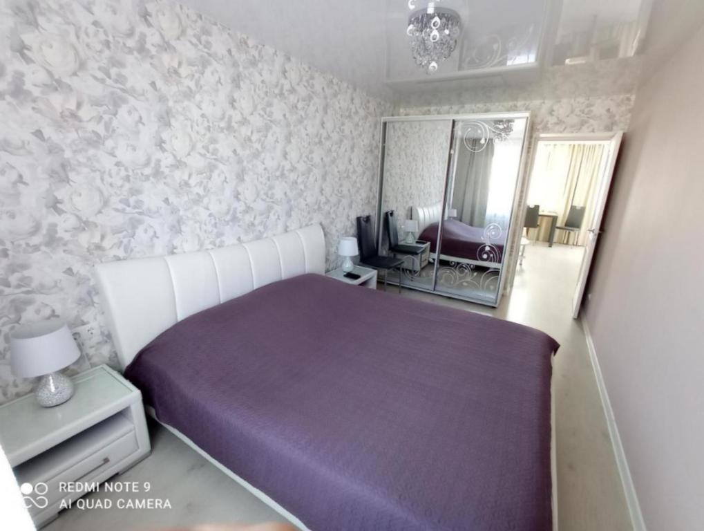 a bedroom with a purple bed and a mirror at Comfortable apartment in center in Narva