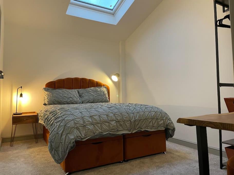 a bedroom with a bed and a skylight at Smithy Bungalow, free private parking included, Buxton in Buxton