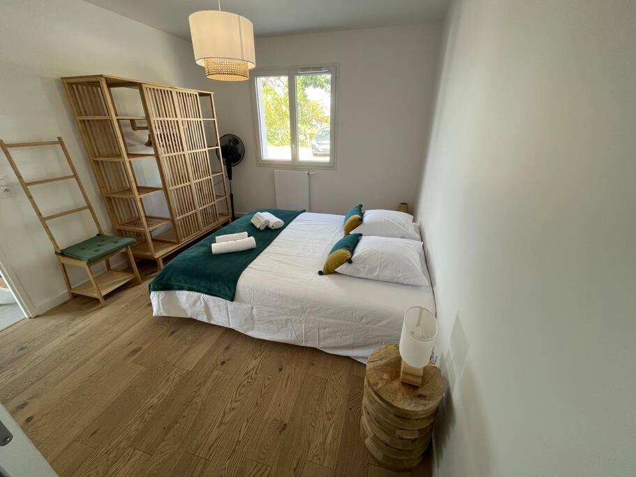 - une chambre avec un grand lit dans l'établissement la villa d'Irissou YourHostHelper, à Andernos-les-Bains