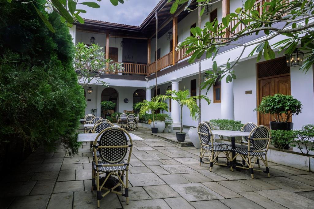 eine Terrasse mit Stühlen und Tischen in einem Gebäude in der Unterkunft Yara Galle Fort in Galle