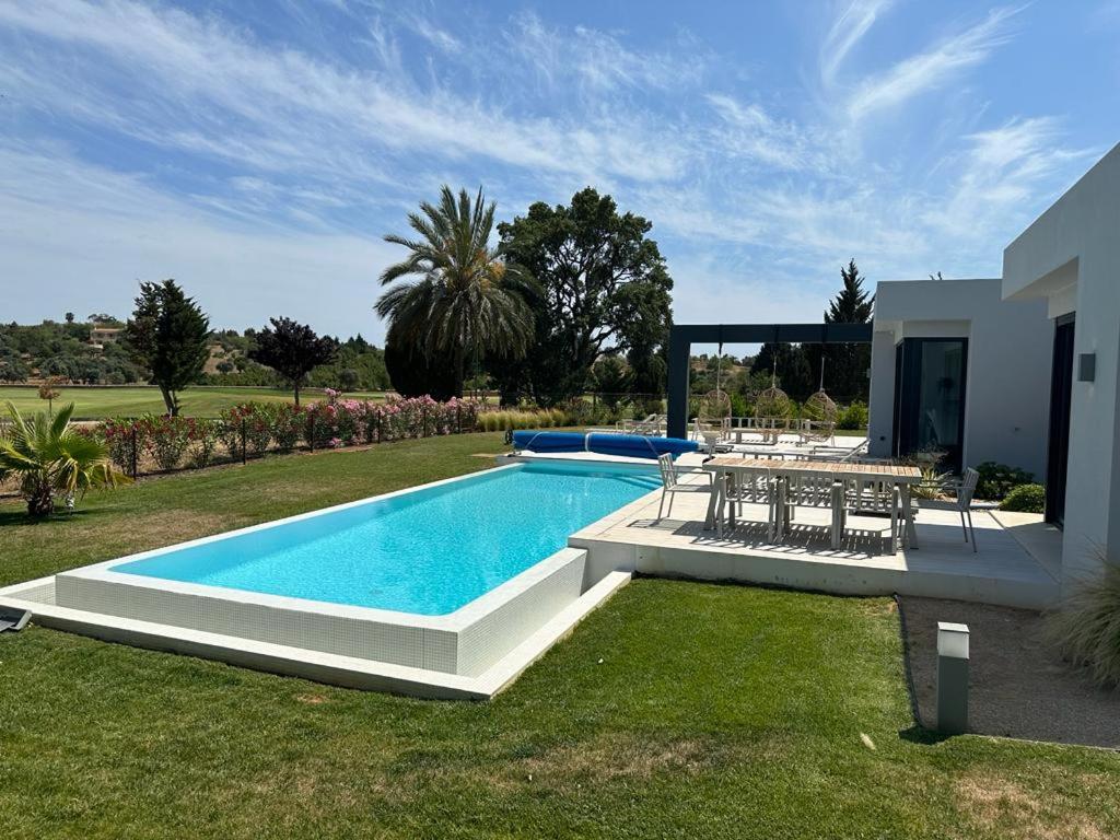 - une piscine avec une table et des chaises dans la cour dans l'établissement Pestana Silves Golf & Residences, à Silves