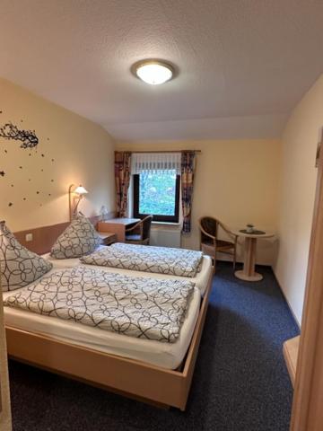 a bedroom with two beds and a room with a desk at Hotel Holtriemer Hof in Nenndorf