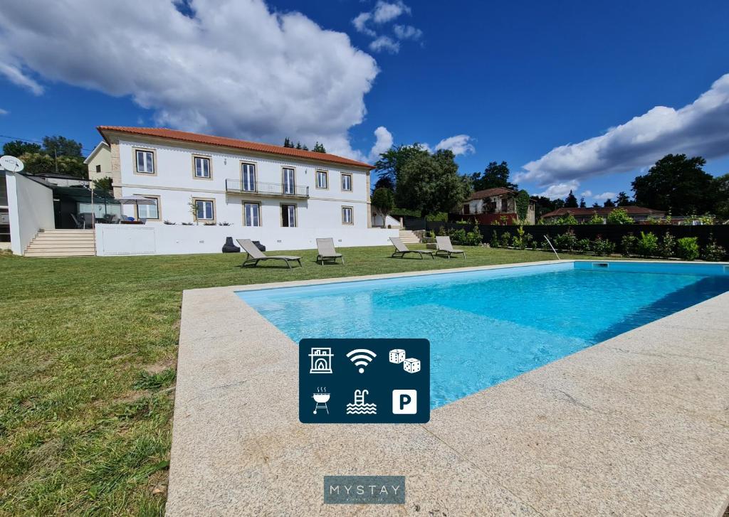 a sign next to a swimming pool in front of a house at Casal Magister in Pedraça