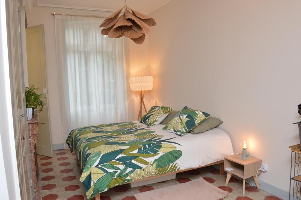 a bedroom with a bed and a lamp and a window at Studio de charme au cœur de Lyon in Lyon