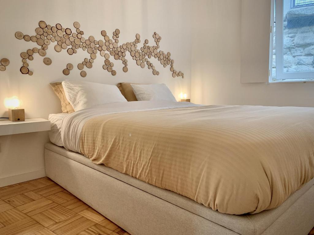 een slaapkamer met een groot wit bed en een kroonluchter bij Porto Cave-styled duplex in Porto