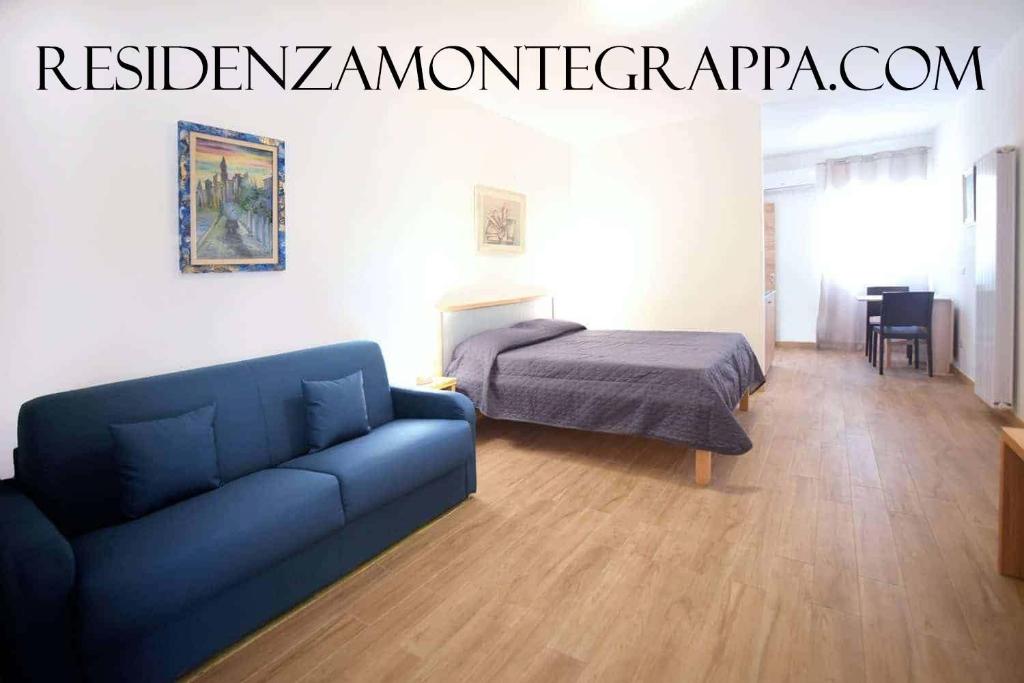 uma sala de estar com um sofá azul e uma cama em Residenza Montegrappa em Peschici
