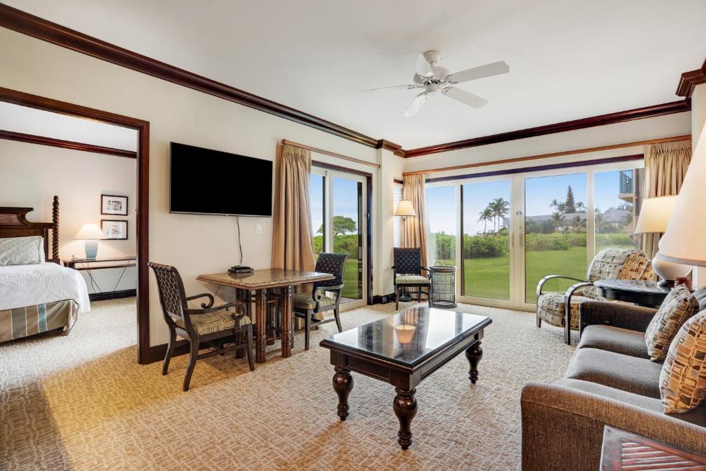 a hotel room with a bed and a living room at Waipouli Beach Resort H105 in Kapaa