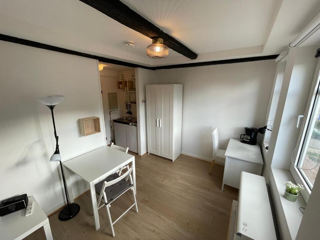 Zimmer mit einem weißen Schreibtisch und einem Tisch in der Unterkunft Liebevoll eingerichtetes Ferienzimmer mit großen Garten in Clausthal-Zellerfeld