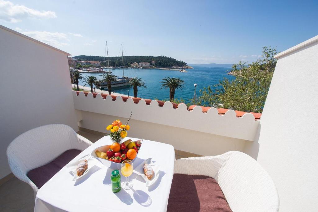 a table with a bowl of fruit on a balcony at Hotel Biokovo in Makarska