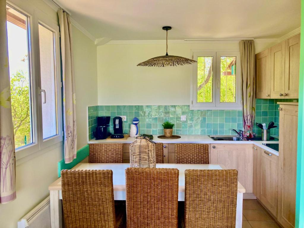 a kitchen with a table with chairs and a sink at Les Restanques 2268 glycines in Grimaud
