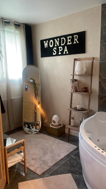 un baño con bañera y un cartel que lee el maravilloso spa en WonderSpa, en Chilly-Mazarin
