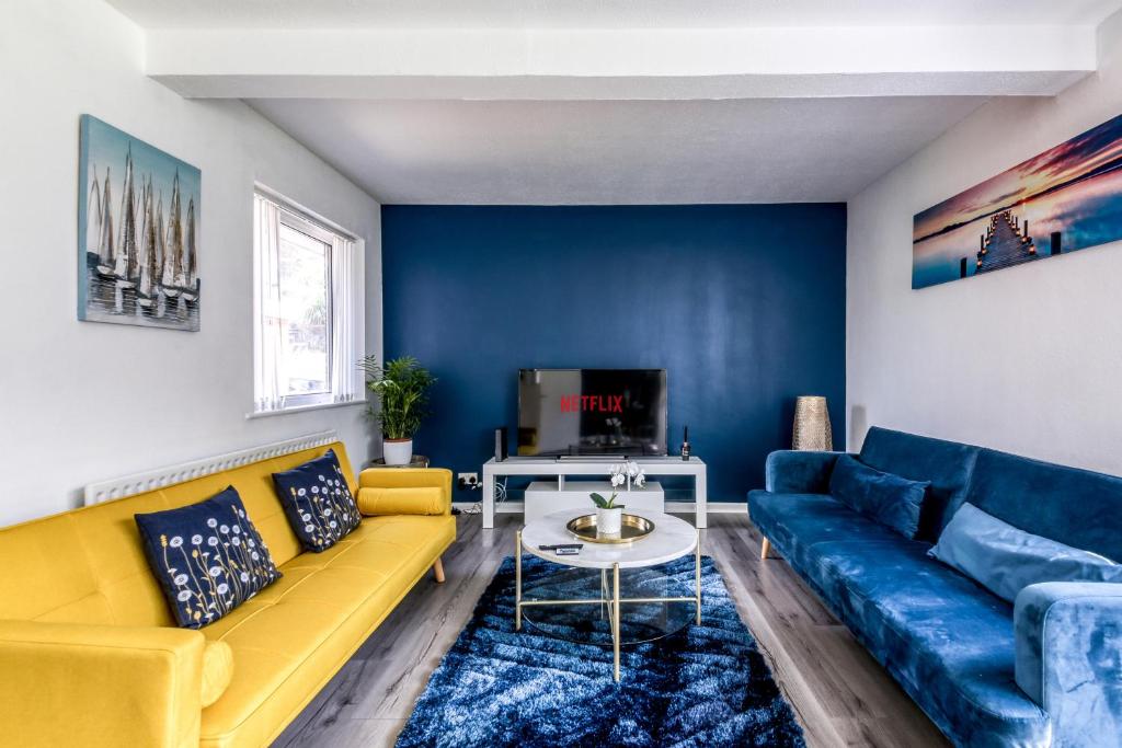 a living room with a yellow couch and blue walls at Contemporary 4 bedroom detached house with parking and city links in Croydon