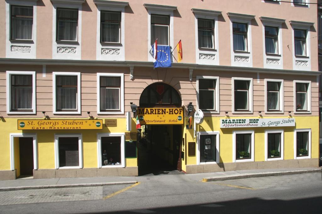 a large yellow and pink building with a door at Appartement Hotel Marien-Hof in Vienna
