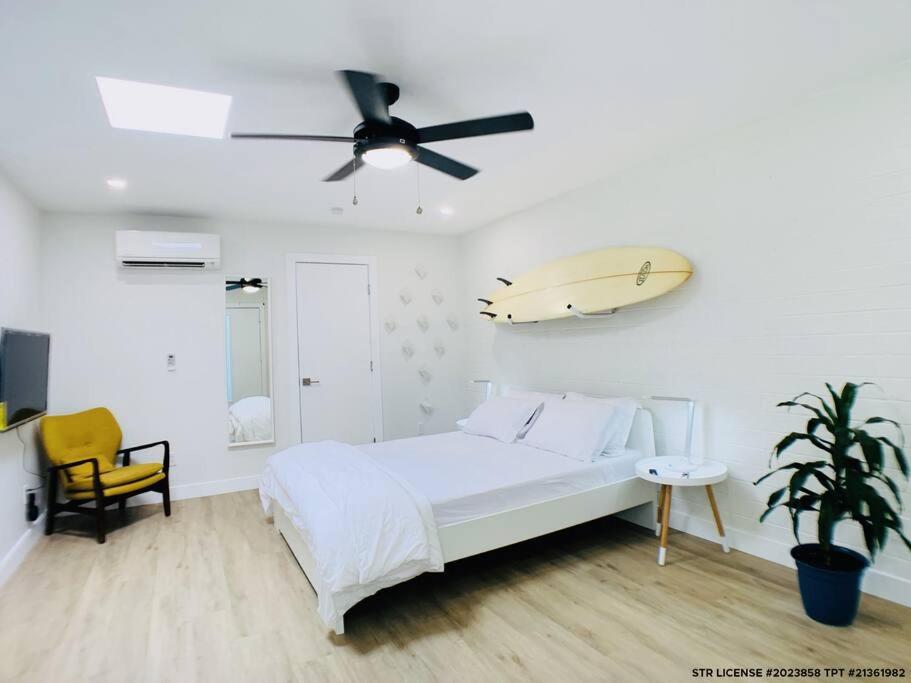 um quarto branco com uma cama e uma prancha de surf na parede em Intimate well appointed Studio w Pool em Scottsdale
