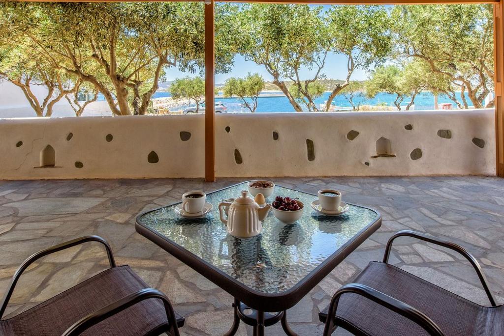 a table with two chairs and a tea set on a patio at Sea Breeze Studios Paros in Aliki