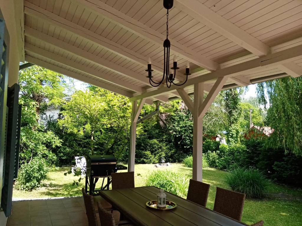 a patio with a wooden pergola with a table and a grill at BalcsiHáz Badacsony in Badacsonytomaj