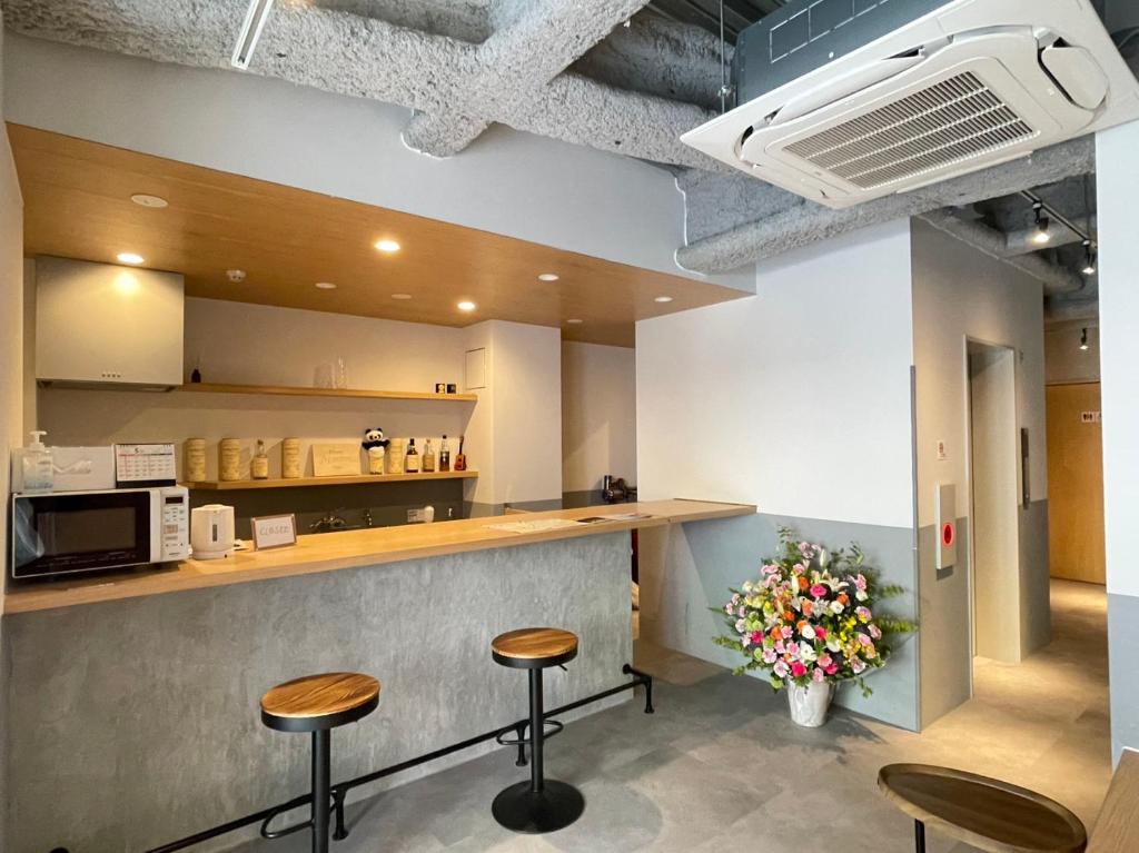 a kitchen with two stools and a counter with a counter top at Hotel Apreton in Tokyo