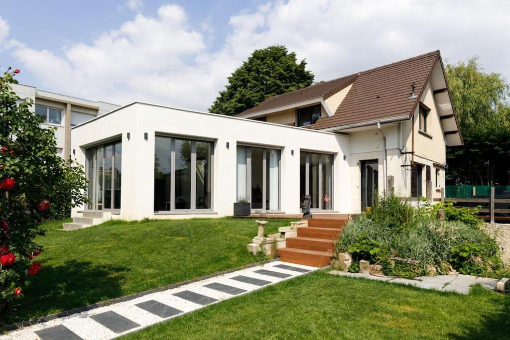 een wit huis met een grasveld bij Welcome Villa moderne belle terrasse et jardin in LʼHay-les-Roses