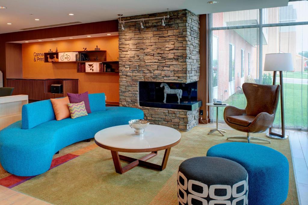 a living room with a blue couch and a fireplace at Fairfield Inn & Suites by Marriott Detroit Troy in Troy