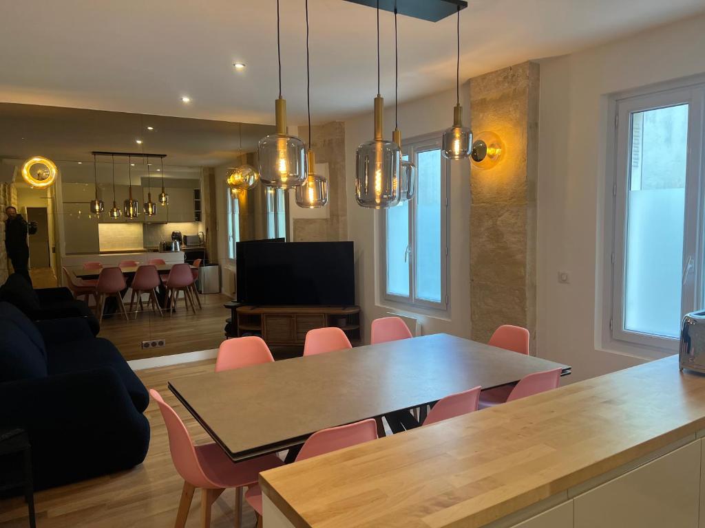 een woonkamer met een tafel en stoelen en een televisie bij Loft 4 chambres Montmartre Pigalle climatisé in Parijs