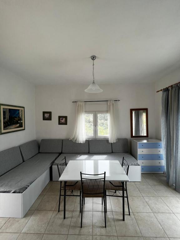 sala de estar con sofá, mesa y sillas en House with View in Mega Ammos, en Sivota