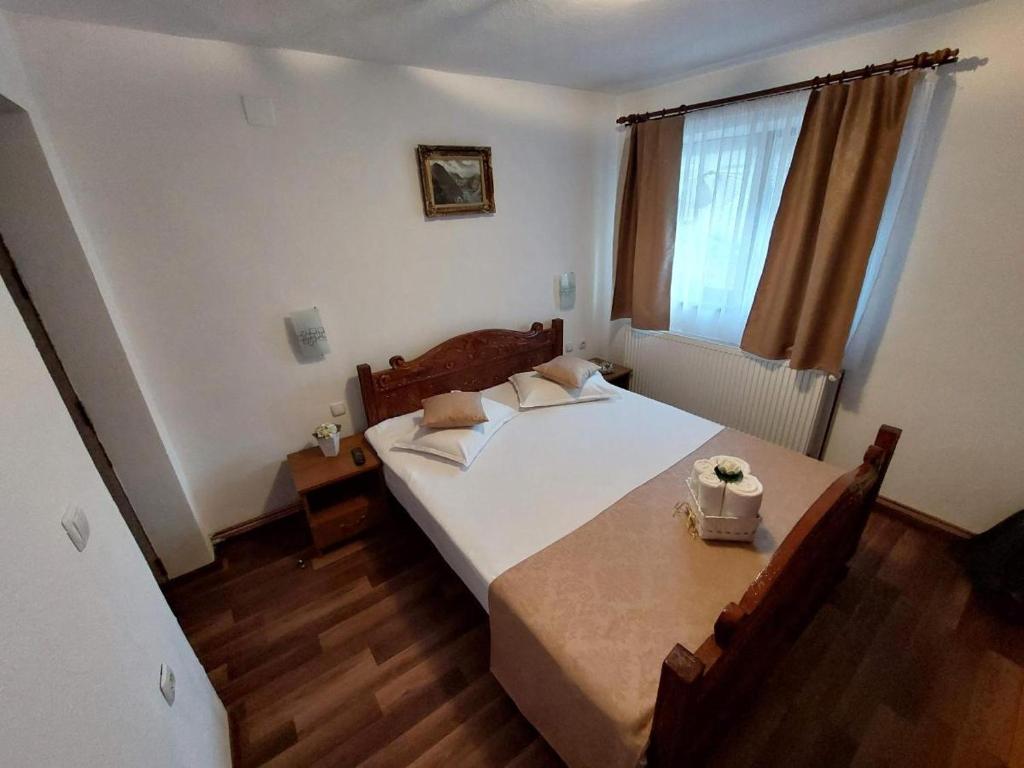 a bedroom with a bed and a table and a window at Casa Fabrizio in Călimăneşti