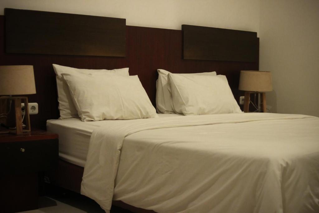 Postel nebo postele na pokoji v ubytování Hotel Graha Kinasih Kotabaru
