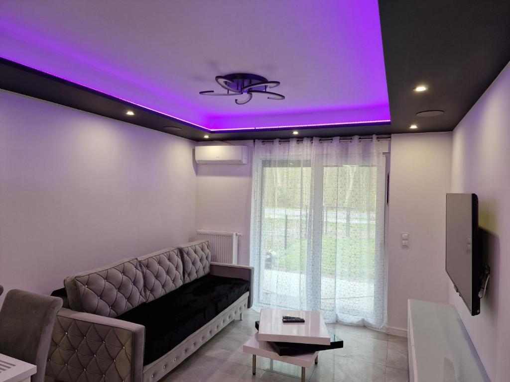 a living room with a couch and a purple ceiling at Apartament Plażowa in Międzywodzie