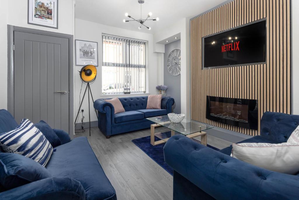 a living room with blue couches and a fire place at Air Host and Stay - Teck House, sleeps 7, mins from Royal Hospital in Liverpool