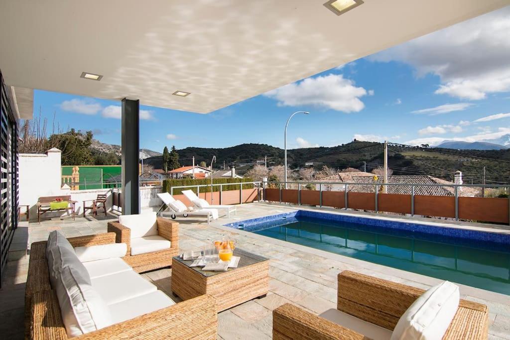 uma casa com uma piscina e um pátio em Relajante villa, deportes, piscina y vistas a S Nevada em Huétor Santillán