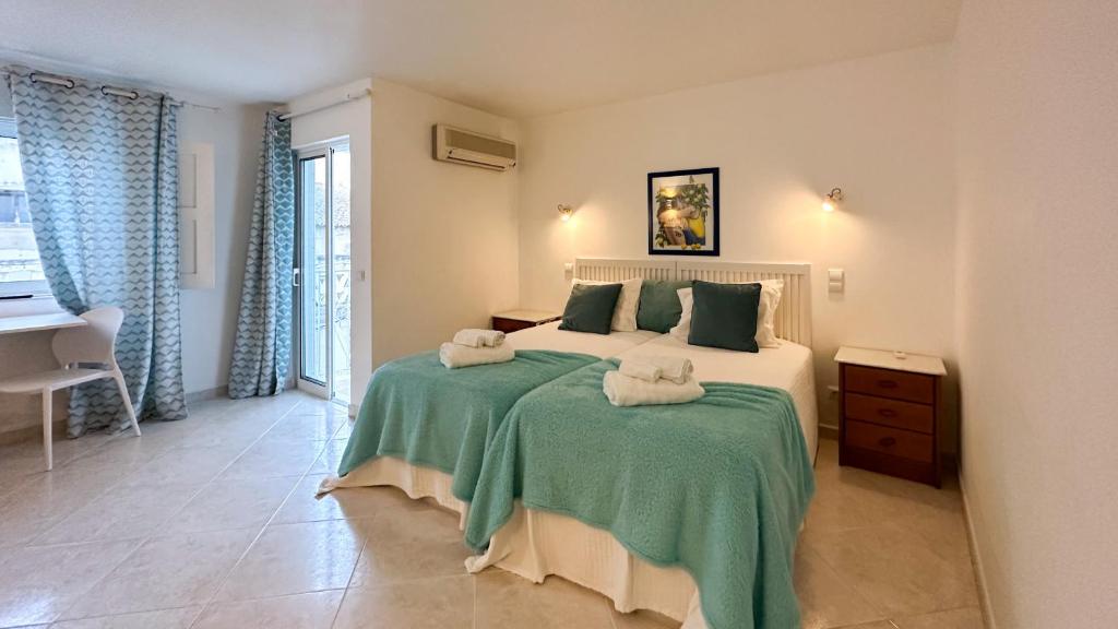 a bedroom with a large bed with towels on it at Sofeelings, Quarto Mar Piso 2, Baixa de Albufeira in Albufeira